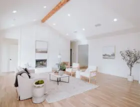 a living room with white furniture and wood floors