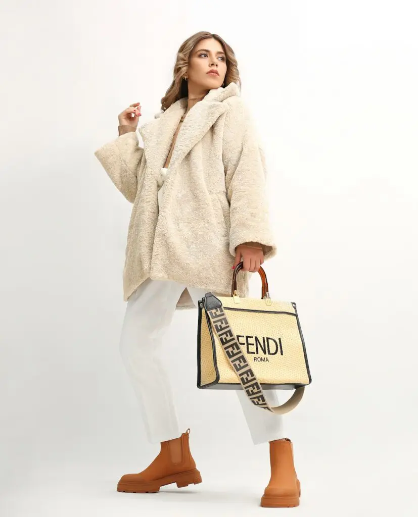 a woman in a fur coat holding a fendi bag